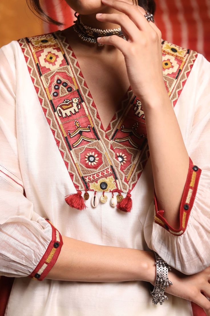 Indulge in a cultural masterpiece with this v-neck chanderi silk kali kurta featuring tribal embroidery and color block design. The rich blend of colors and intricate tribal embroidery create a captivating ensemble. Crafted in luxurious chanderi silk, this kurta elegantly fuses tradition and modernity. Elevate your style and make a distinctive statement with this artful and enchanting piece. Suit Sleeves, Kutchi Work, Designed Dresses, Embroidery Kurta, Linen Style Fashion, Kurta Patterns, Kurta For Women, Kurta Set For Women, Simple Kurta Designs