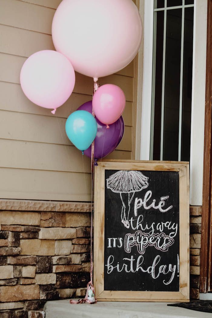 a chalkboard sign with balloons attached to it