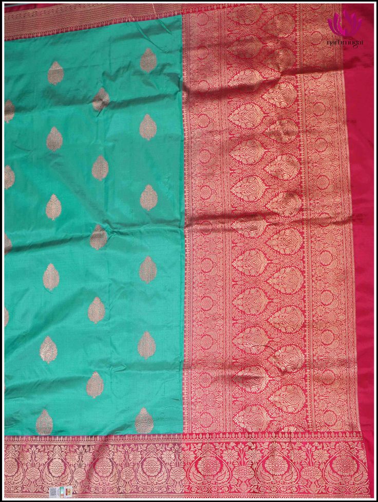 Adorn yourself in this Banarasi Katan silk saree in turquoise Blue with rigorously crafted zari woven floral motifs sprinkled over the fabric. The alluring blue body teams up with the pinkish red border and pallu. The zari woven floral pattern in pinkish red hue beautifully blends with the fabric, which results in grabbing attention with every move. The harmonious combination of blue and red is visually appealing, making this saree a perfect choice for those, who seeks elegance and vivacity for Turquoise Saree With Zari Work For Puja, Traditional Turquoise Wear With Zari Weaving, Festive Turquoise Silk Traditional Wear, Turquoise Pallu Saree, Turquoise Banarasi Silk Traditional Wear, Traditional Turquoise Saree With Zari Weaving, Turquoise Handloom Saree For Festivals, Turquoise Traditional Wear With Zari Weaving, Turquoise Saree With Cutdana For Puja