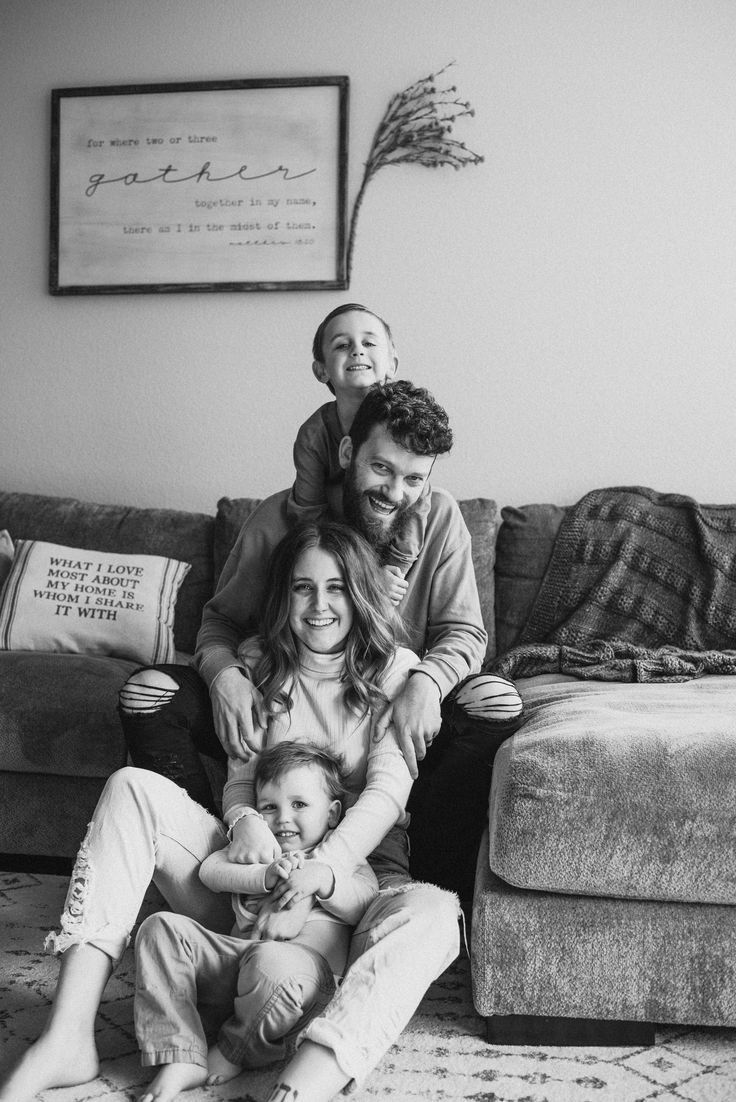 a black and white photo of a family sitting on the couch in their living room