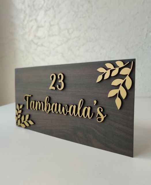 a wooden sign that says 23 tambawada's with leaves on it