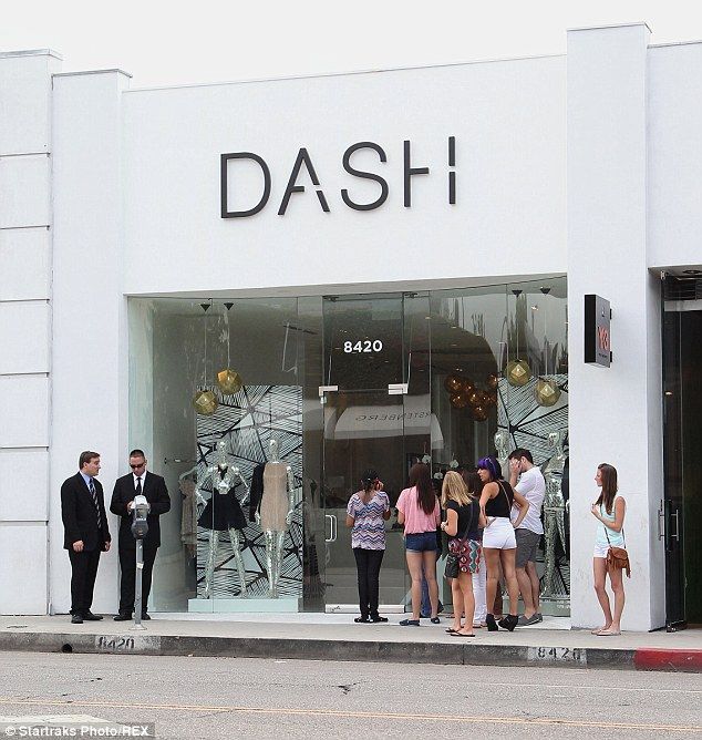 people are standing in front of a store window with the word dash on it's side