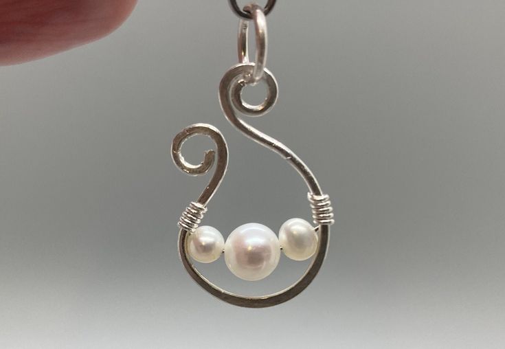 Natural white pearls and sterling silver. Genuine pearls "floating" in hand-wrought sterling silver. Earrings each have one 6mm pearl and measure approximately 18mm x 12mm. Pendant has one 6mm pearl and two 4mm pearls and measures approximately 24mm x 15mm. These are handmade, so please expect some slight variation. Please note that the pendant does not come with a chain. Purchase as a set or as one pair of earrings and/or one pendant.  Pearls are the birthstone for June, and they're just classy. I personally select the beads and materials from the very best in my stock to ensure that you are happy with your product. Please let me know if for any reason you are not.  View my other listings at https://www.etsy.com/shop/cultivatedelements/. Sterling Silver Pearl Pendant Earrings, Unique Sterling Silver Pearl Earrings As Gift, Hand Forged Dangle Pearl Earrings For Gifts, Silver Wire Wrapped Pearl Earrings Gift, Hand Forged White Jewelry For Gifts, Earring Ideas, Pearl Earring, Wedding Jewelry Earrings, Wedding Earrings