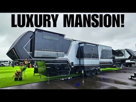 an rv park with many different types of recreational vehicles parked on the grass and one is advertising luxury mansion