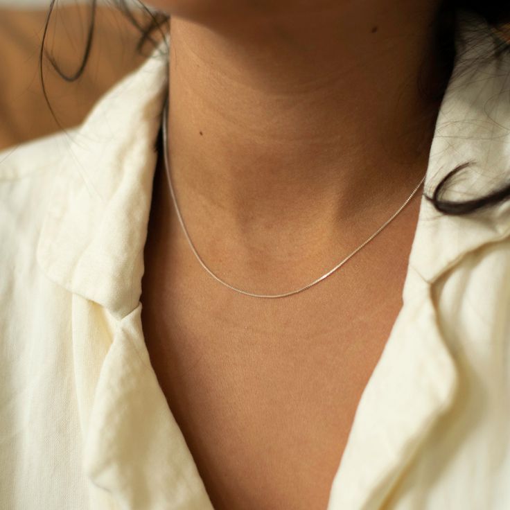 "Sterling Silver Box Chain Necklace from our necklace collection. A classic jewelry staple that is shiny from every angle, our sterling silver box chain necklace is more refined and daintier for an everyday look. Whether you wear it on its own, layer it with other necklaces or add a pendant, you will find unlimited options to style this beautiful chain. CHAIN DETAILS ⚬ Sterling silver box chain ⚬ .64mm thick x 16\" long ⚬ Spring ring clasp closure ABOUT OUR LAYERING CHAIN COLLECTION Whether you Classic Silver Snake Chain Necklace For Everyday, Silver Classic Snake Chain Necklace, Classic Silver Snake Chain Necklace With Adjustable Chain, Sterling Silver Delicate Snake Chain Necklace Gift, Classic Sterling Silver Snake Chain Necklace Gift, Classic Sterling Silver Snake Chain Necklace, Dainty Silver Snake Chain Necklace With Delicate Chain, Dainty Silver Snake Chain Necklace With Delicate Details, Classic Silver Hypoallergenic Chain Necklace