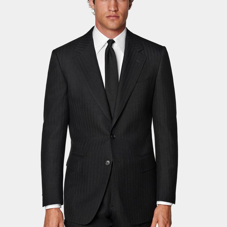 This black herringbone suit is cut to a tailored fit with a slim chest and waist for a fitted silhouette, padded shoulders, and a single-breasted closure. Paired with straight-leg trousers featuring a mid-rise and flat front. Classic Black Pantsuit For Semi-formal Occasions, Timeless Formal Pantsuit, Luxury Tailored Black Pantsuit, Black Business Casual Pantsuit With Pressed Crease, Black Semi-formal Professional Pantsuit, Black Pantsuit With Pressed Crease For Business Casual, Luxury Black Formal Pantsuit, Black Professional Semi-formal Pantsuit, Black Professional Pantsuit For Formal Occasions