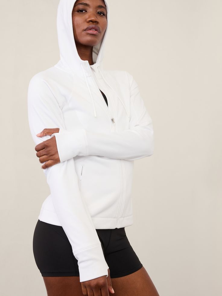 FOR: Medium to high-impact workouts at the gym, studio, or outdoors FEEL: Flex Fleece fabric has a cozy, brushed feel with all-around stretch FAVE: Thumbholes hold sleeves in place and keep warmth in Secure zip pockets to store your essentials Internal pocket to stash essentials Semi-fitted, skims easily over the body Regular length, hits at the hip Body length in size medium: Regular: 25" Petite: 24" Plus: 28" Tall: 27". White Activewear With Drawstring Hood For Workout, White Drawstring Hood Activewear For Workout, White Drawstring Hooded Activewear For Workout, High Stretch Athleisure Outerwear For Gym, White Functional Track Jacket For Workout, High Stretch Athleisure Outerwear For Training, White Athleisure Activewear With Drawstring Hood, Functional White Track Jacket For Workout, White Activewear With Drawstring Hood For Gym