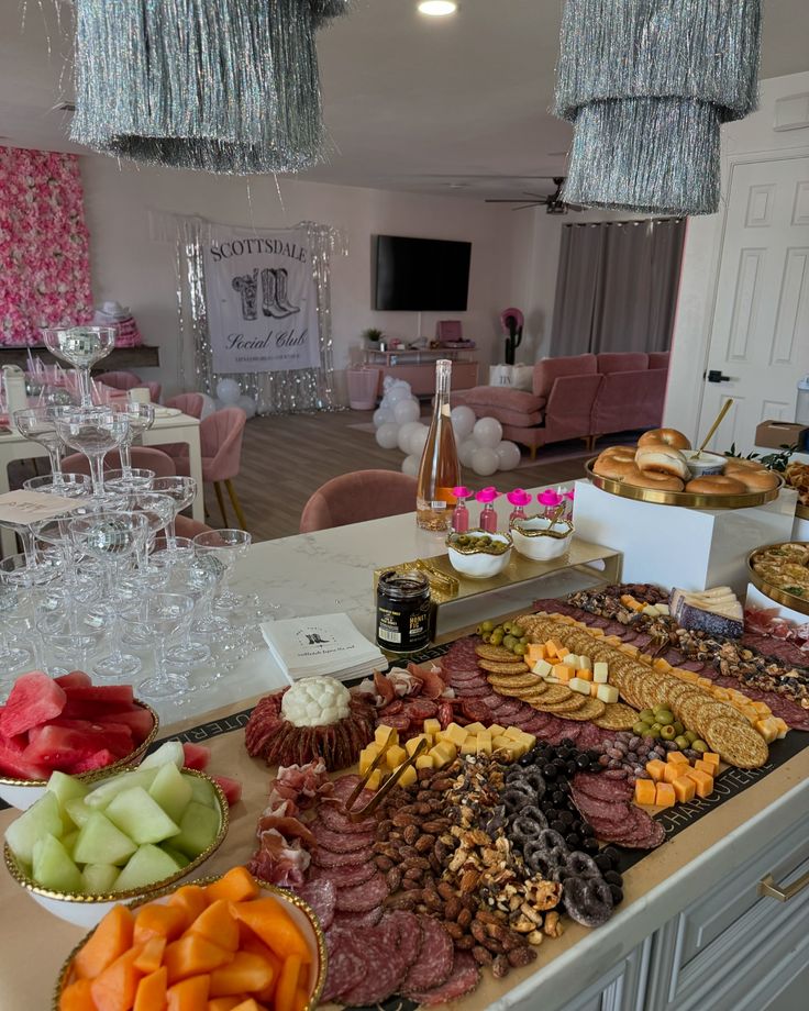 a table filled with lots of different types of food on top of a white counter