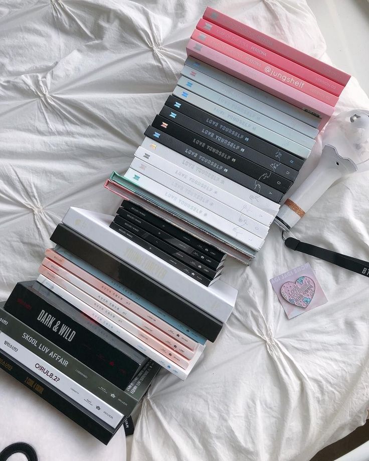 a stack of books sitting on top of a bed next to a pair of scissors