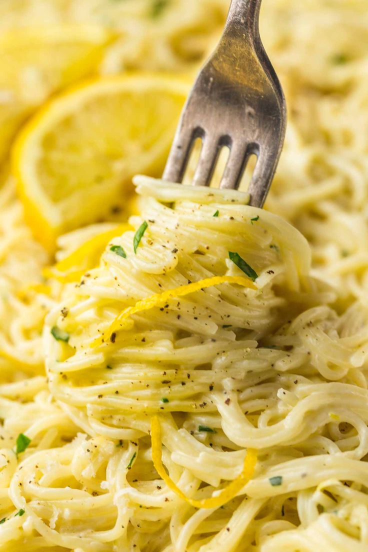 a fork with some noodles and lemons on it