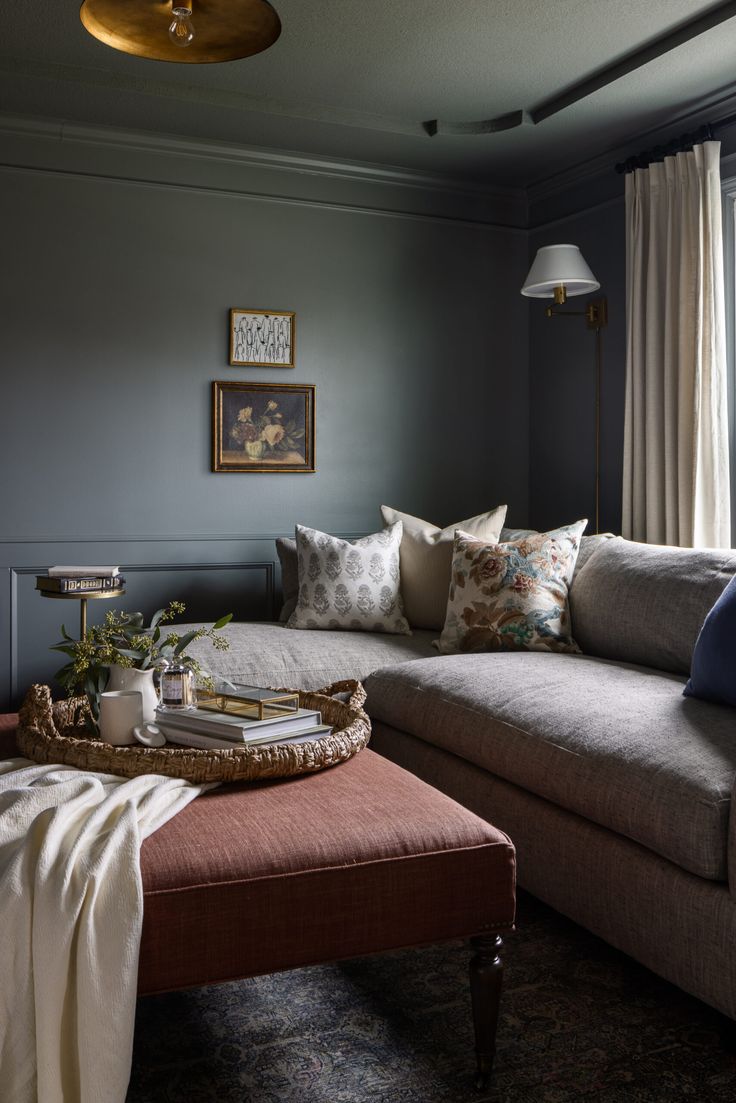 a living room filled with furniture and a large window next to a couch covered in pillows