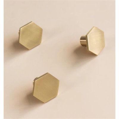 three brass hexagonal knobs on a white background