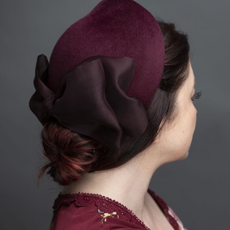 Elegant calot of merlot velour fur felt. Trimmed with a matching asymmetrical silk organza bow. Lined in pure silk. Perches gently on the back of the head. Easy and comfortable to wear with a comb and horsehair loops for pinning into place. One size fits most. Lifted Millinery headwear is constructed with time honored techniques and fine craftsmanship. All hats are meticulously blocked and sewn by hand without the use of adhesives to attach trims. This ensures a long lasting hat with the ability Millinery Diy, Organza Bow, Veiled Hats, Vintage Millinery, Back Of The Head, Big Hat, Vintage Hats, Love Hat, Hat Box