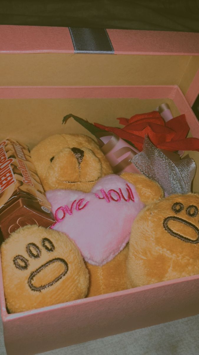 a pink box filled with teddy bears and candy