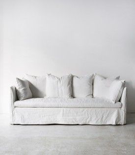 a white couch sitting in front of a window