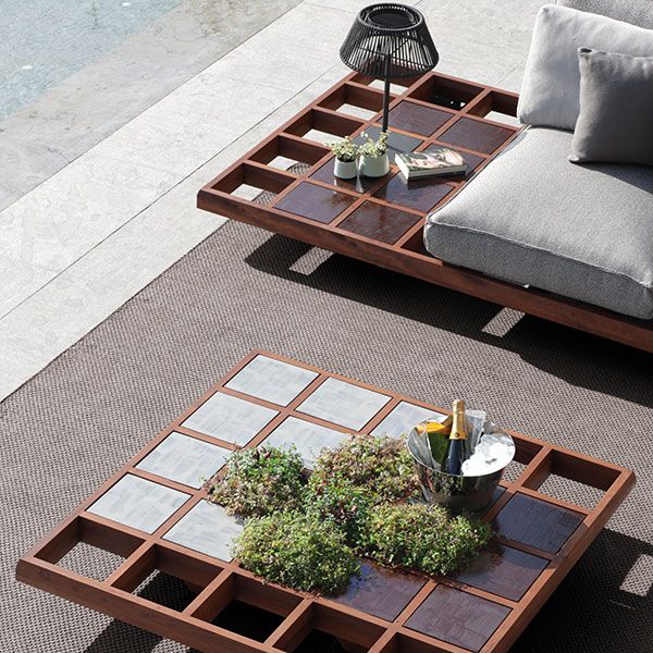 two coffee tables sitting on top of a rug next to a pool