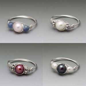 four different types of rings with pearls and beads on each one, all in silver