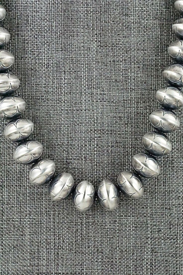 This sterling silver Navajo pearl necklace was made by Navajo silversmith Bryannen Halwood.Necklace: 17"Bead size: 5/8" x 1/2"Free shipping on all orders! We ship with USPS and always include tracking. All orders ship within a day of payment.Returns are accepted up to 30 days after you receive your order. Just send us a message. Our shop offers cash back or store credit. The item must be returned in new condition. Southwestern Silver Beaded Necklace With Sterling Clasp, Southwestern Silver Necklace With Large Beads, Southwestern Style Silver Single Strand Necklace, Silver Southwestern Engraved Necklace, Southwestern Silver Engraved Necklaces, Silver Engraved Southwestern Necklace, Hand-strung Silver Artisan Beaded Necklace, Engraved Silver Southwestern Necklace, Silver Southwestern Jewelry With Large Beads