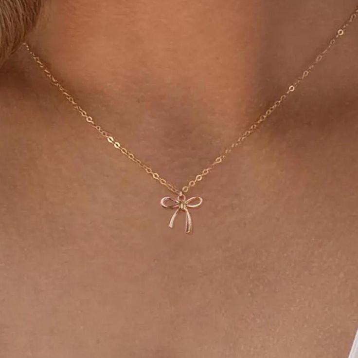 🌸Beautiful golden bow handmade necklace with gold or silver plated chain! Nickel Free! Perfect gift for girlfriend, friend, or gift for yourself!  💎PRODUCT DETAILS:  - Comes in variety of Chain lengths  - Chain material, 14k gold or silver plated Iron - Color may vary from lighting on computer to actual color.  🛒HOW TO ORDER: 1.) Select chain length 2.) Add to cart 3.) Checkout 📩Message us with any questions!  🛍️OTHER GIFT IDEAS:      -Gold Letter Stanley Handle Charm https://www.etsy.com/l Cute Gold Clavicle Chain Jewelry, Cute Gold Charm Necklaces With Clavicle Chain, Cute Gold Charm Necklace With Clavicle Chain, Gold Necklace With Ribbon For Gift, Gold Necklace With Ribbon Perfect For Gifts, Dainty Ribbon Jewelry For Gifts, Cute Gold Jewelry With Delicate Chain, Delicate Ribbon Necklace Gift, Cute Gold Necklaces For Party