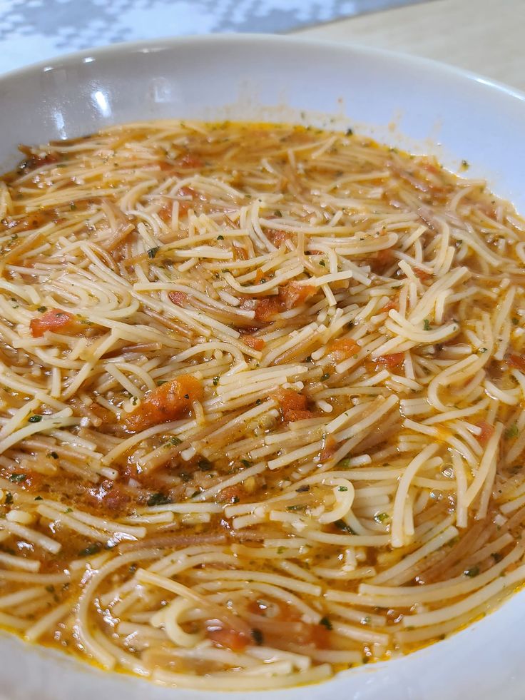 a white bowl filled with pasta and sauce