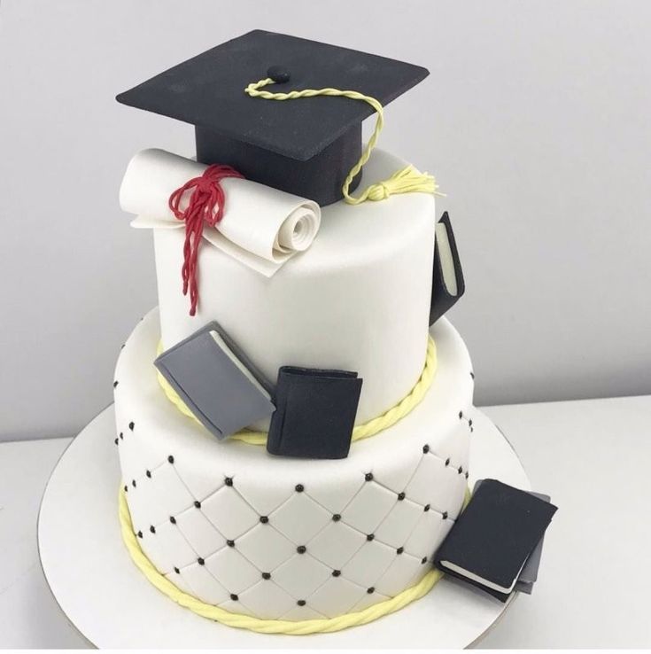 a graduation cake with books and mortars on top