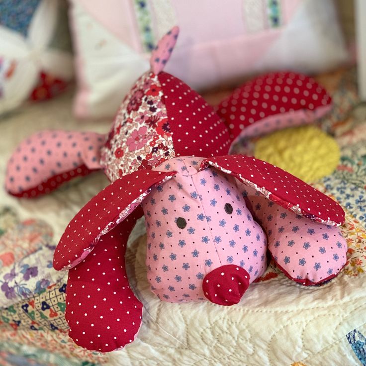 a pink stuffed animal sitting on top of a bed