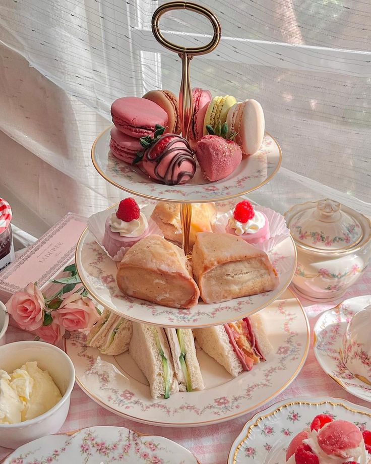 three tiered trays filled with different types of pastries and desserts on plates