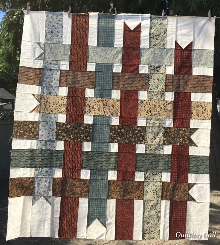 a quilt hanging on a clothes line outside