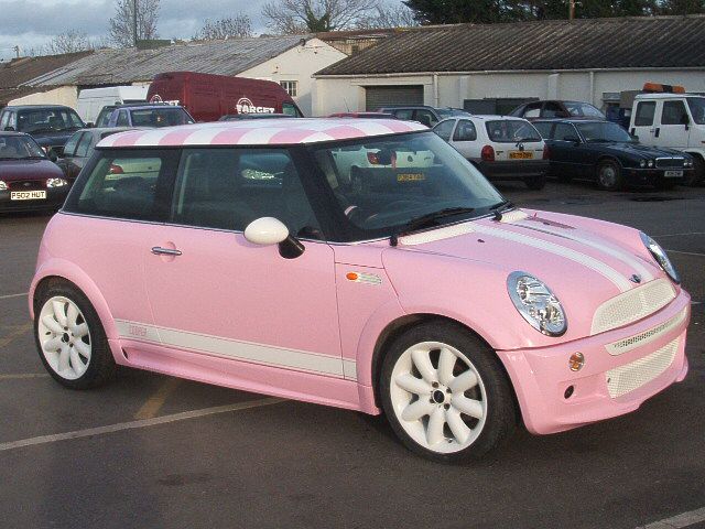 a pink and white car parked in a parking lot