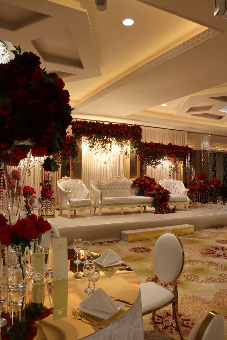 a room filled with lots of tables covered in flowers and white chairs sitting next to each other