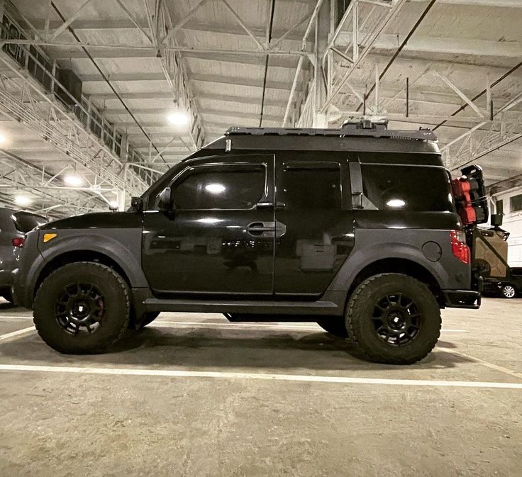 an suv parked in a parking garage next to another vehicle with its lights turned on