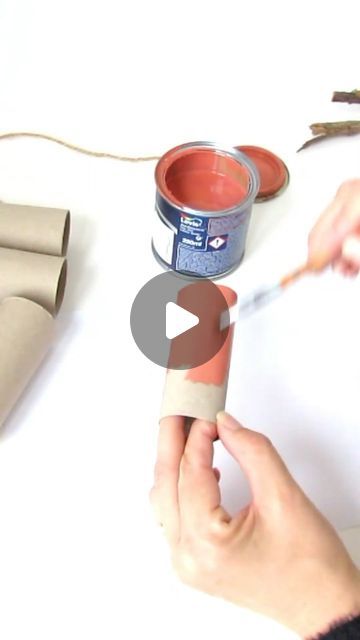 someone is painting the inside of a can with red paint and some brown paper tape