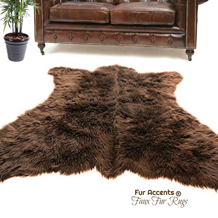 a brown leather couch sitting next to a sheepskin rug