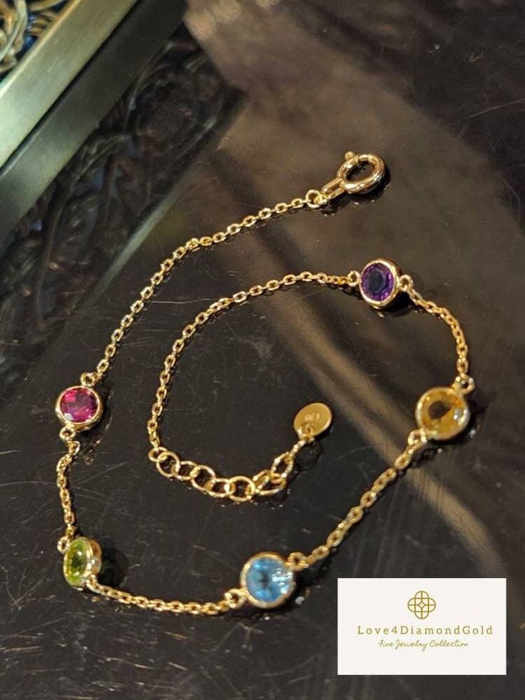 Gift yourself or your loveonce this beautiful Dainty Gem Bracelet. Set in 18 Karat of Gold. * Materials: 18Karat Gold, Citrine, Amethyst, Blue Topaz, Pink Sapphire, Peridot * Gold Color: Yellow Gold * Chain Length: 6.5 Inches-7.5 Inches (Adjustable) * Chain Width: .9mm *Gem Width: 4.6mm * 5 Gemstones * Weight: 1.32grams 💎 NOT Gold Plated; Not Gold Filled. *Some photos might be enlarged to get an accurate description and image. Pls see the item's description before checking out. 💥PLS FOLLOW US Elegant Gold Crystal Bracelet With Birthstone, Elegant Gold Crystal Birthstone Bracelet, Gold Bracelets With Gemstone Accents As Gift, Luxury Multi-stone Bracelets As Gift, Gold Cubic Zirconia Bracelet With Gemstone, Yellow Gold Cubic Zirconia Crystal Bracelet Gift, Fine Jewelry Multi-stone Bracelet As Gift, Fine Jewelry Multi-stone Bracelets For Gifts, Cubic Zirconia Bracelets With Gemstone Accents Gift