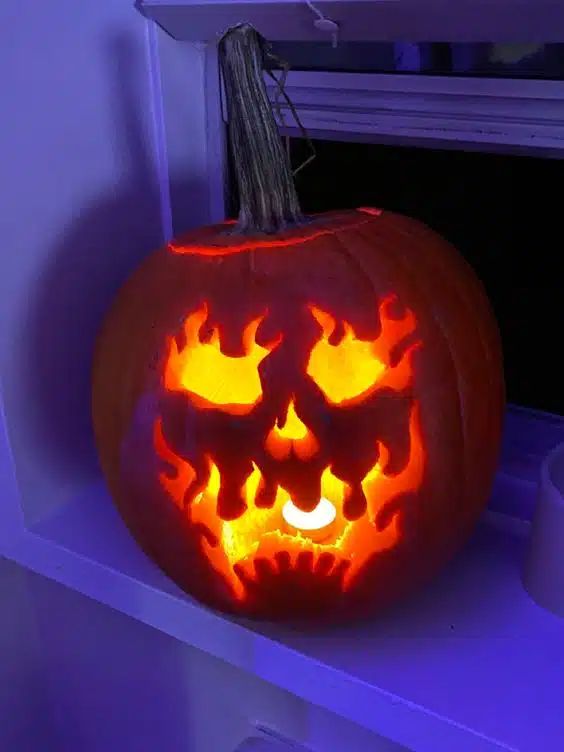 a carved pumpkin sitting on top of a window sill