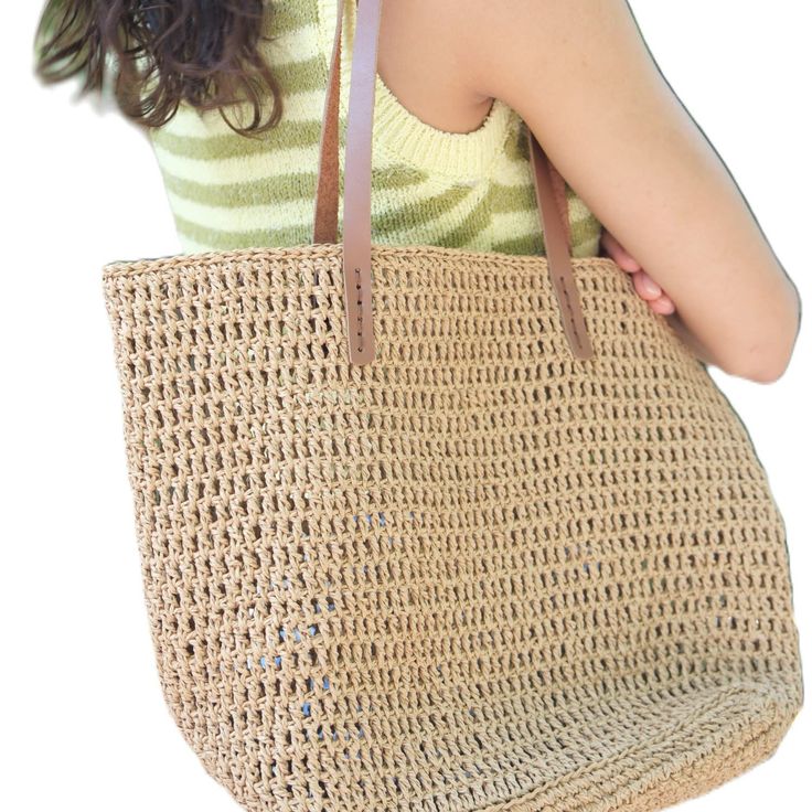 These bags are  handmade and crafted from raffia yarn. Raffia yarn is a natural and durable material, ensuring the longevity of the bags. The handles are made from genuine leather, adding extra durability and a touch of elegance. The sturdy base structure helps the bags stand upright and keeps the contents organized. Available in beige and reddish-brown colors, these bags are ideal for beach trips, shopping, or daily use due to their spacious interiors.  Bag dimensions:  Width: 41 cm Height: 30 Eco-friendly Beige Bags With Braided Handles, Natural Jute Bucket Bag With Braided Handles, Natural Fiber Crochet Bag With Leather Handles, Chic Natural Woven Crochet Bag, Chic Open Weave Jute Bag, Beige Beach Bag With Braided Handles In Natural Fiber, Handwoven Beige Bag For Vacation, Beige Natural Fiber Beach Bag With Braided Handles, Natural Jute Bucket Bag For Daily Use