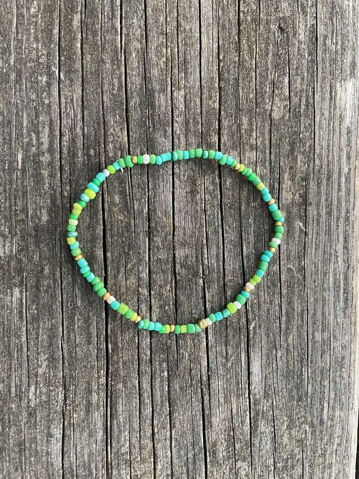 Green and gold seed bead bracelet themed for fall or winter, great for any occasion or a gift, made from seed beads and elastic cord. Green Bohemian Hand-strung Friendship Bracelets, Bohemian Green Hand-strung Friendship Bracelets, Adjustable Green Beaded Bracelets With Gold Beads, Green Beaded Bracelet With Gold Beads, Adjustable Green Bracelets With Gold Beads, Bohemian Green Beaded Bracelets With Gold Beads, Bohemian Green Friendship Bracelets With Colorful Beads, Casual Green Stretch Bracelet With Spacer Beads, Casual Green Hand-strung Beads