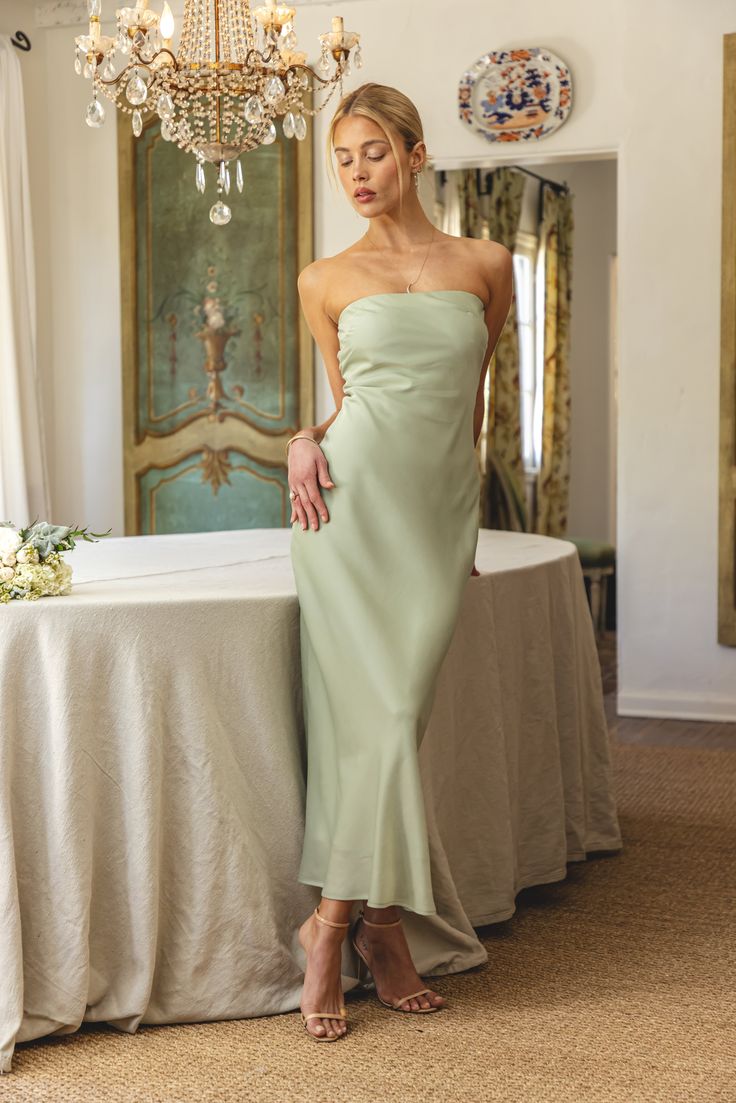 a woman standing next to a table with a chandelier