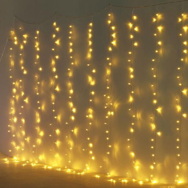 a wall covered in yellow lights next to a fire hydrant