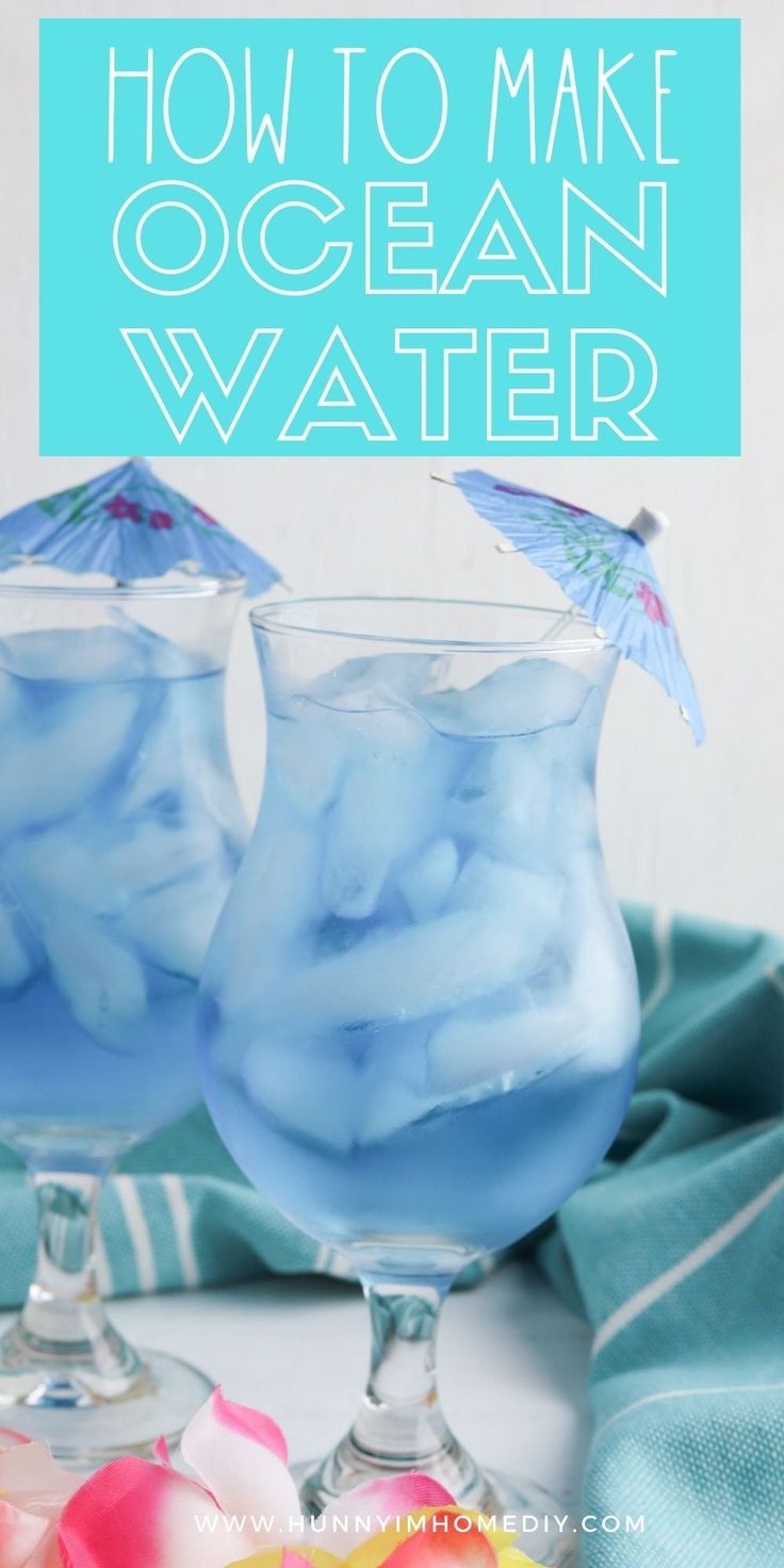 two glasses filled with blue liquid sitting on top of a table