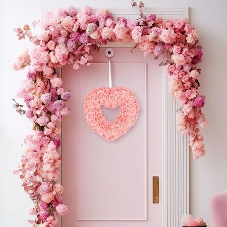 a pink door decorated with flowers and a heart