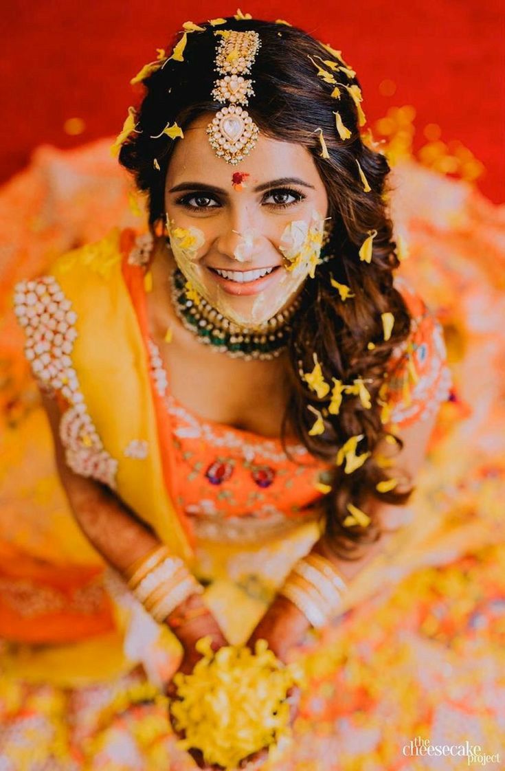 a woman in yellow and gold is posing for the camera