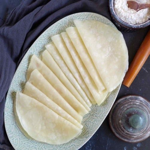 several pieces of flat bread on a plate next to some salt and pepper shakers