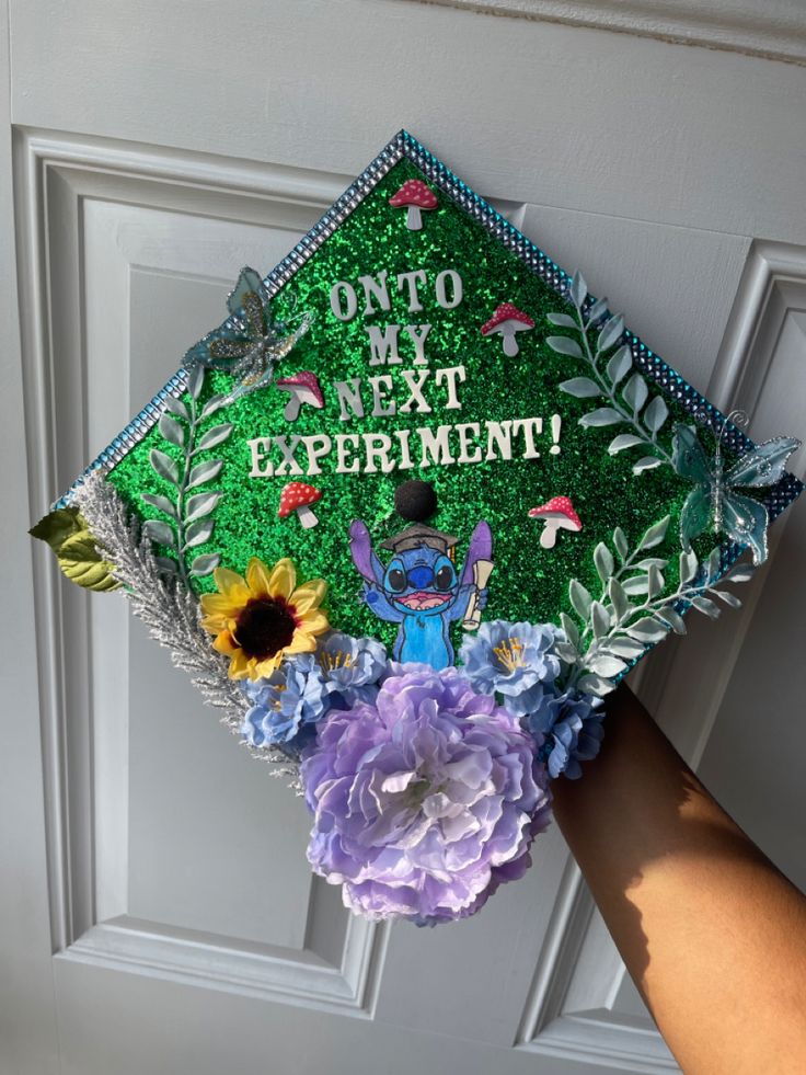 someone is holding up a decorated graduation cap