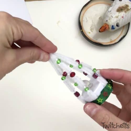 someone is making a miniature christmas tree out of toilet paper and other crafting supplies