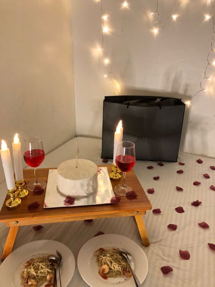 two plates with food on them and candles in front of the plate are sitting on a table