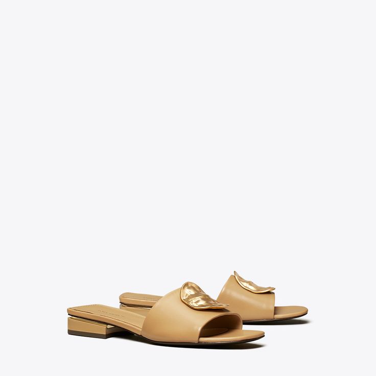 Our Patos slide is defined by an oversized metal disc, evocative of ’60s glamour. Crafted in soft leather with a cushioned insole, the sandal is set on an understated block heel for a slight lift.Crafted in partnership with a Leather Working Group-certified tannery, supporting high standards in leather manufacturing and chemical management. Chic Slides With Leather Footbed, Chic Formal Slides With Leather Footbed, Chic Formal Flat Slides, Chic Slides With Leather Sole, Chic Gold Leather Slides, 60s Glamour, Ginger Shortbread, Plastic Heels, Footwear Design Women