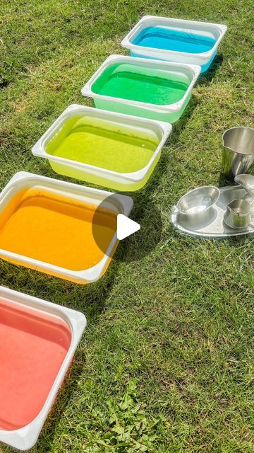 four different colored trays on the grass with measuring cups and spoons next to them