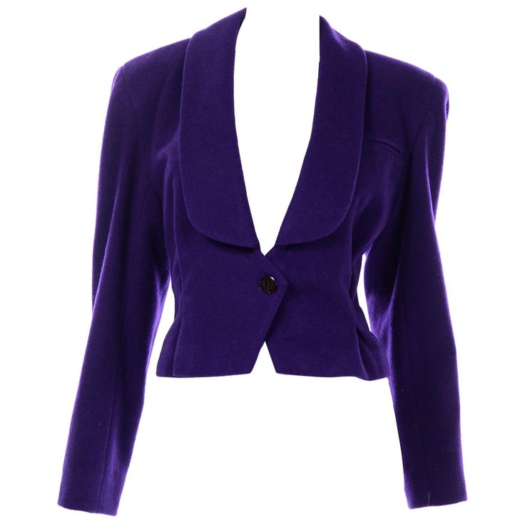 This Norma Walters cropped wool jacket is so fabulous! The wool + cashmere blend is in a rich purple and this piece is sure to elevate any outfit. There is a front button closure and one small faux breast pocket. There are two darts on the front of the jacket that create a box pleat. The back of the jacket also has this dart/pleat detail close to the hem. There is a suede-back belt with a red belt bucket in the center of the two belt straps. This feature allows for the jacket to be tighter aroun Fitted Wool Cropped Jacket For Office, Elegant Wool Cropped Jacket With Buttons, Formal Long Sleeve Wool Cropped Jacket, Formal Wool Cropped Jacket For Winter, Elegant Fitted Wool Cropped Jacket, Wool Cropped Jacket With Buttons, Elegant Single Breasted Wool Cropped Jacket, Elegant Wool Cropped Single-breasted Jacket, Elegant Wool Single-breasted Cropped Jacket