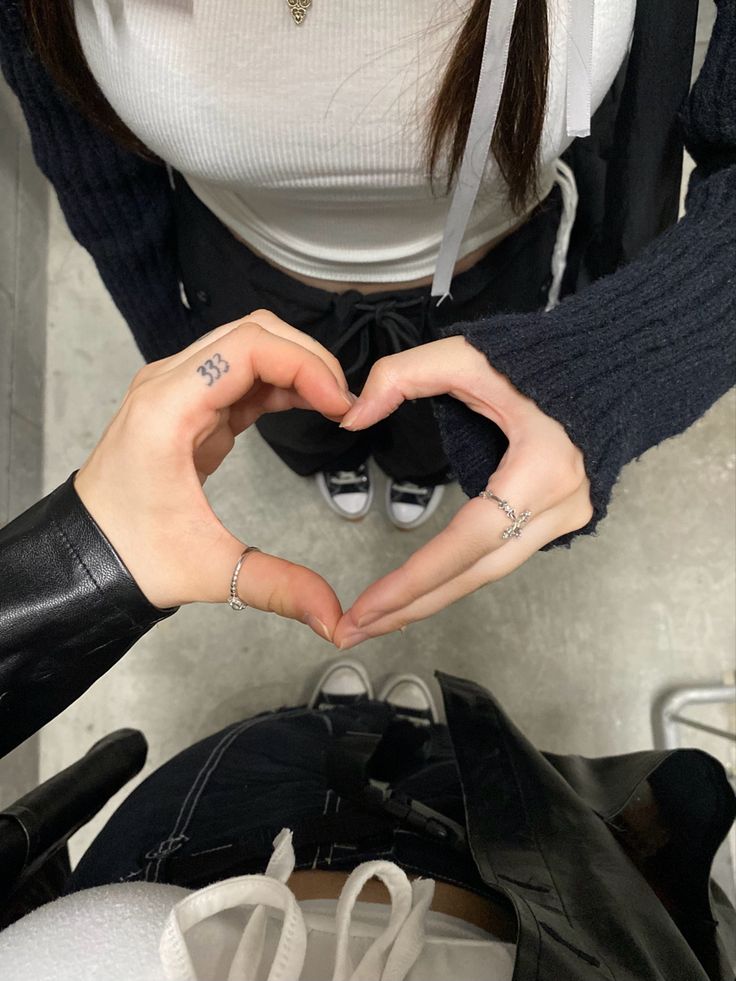 a woman making a heart shape with her hands